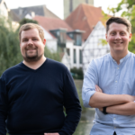 Gardia Founders Michael Hummels and Marlon Besuch standing outdoors with traditional buildings in the background.