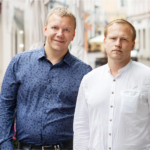 Two male founders standing in a European city street