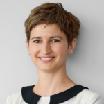 Woman with short brown hair smiling in light clothing
