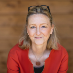 Karenina Schröder, BONVENTURE Advisor in a red blouse smiling slightly at the camera.