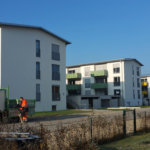 Residential apartment buildings with green balconies and maintenance truck, Fenecon Mieterstrom