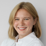 Blonde woman with short hair in a white blouse smiling