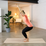 Woman practicing yoga in a modern living room.
